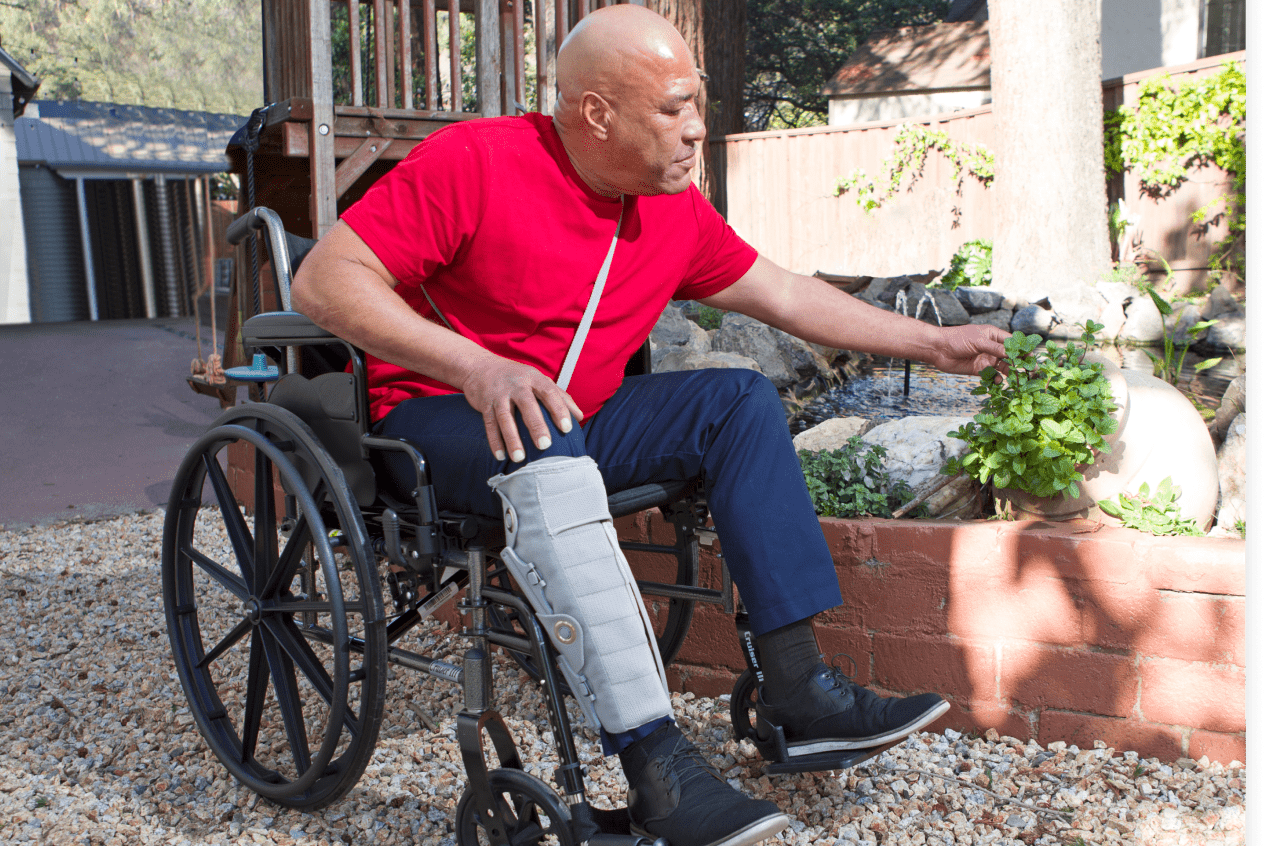 Man in wheelchair wearing lymphedema sleeve on leg